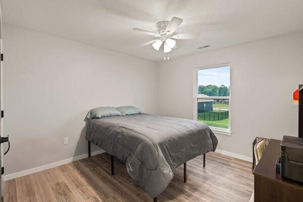 bedroom with ceiling fan and hardwood / wood-style flooring