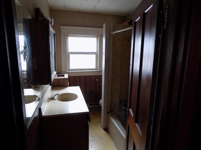 full bathroom featuring vanity, shower / bathtub combination, toilet, and wooden walls