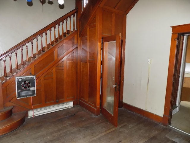 staircase with baseboard heating and concrete floors