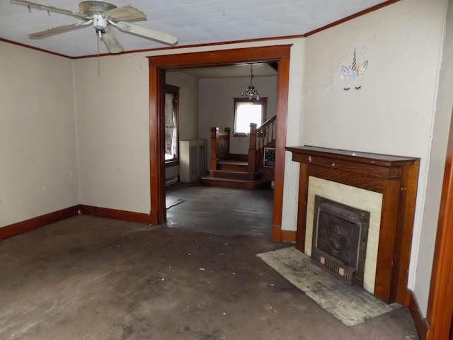 unfurnished living room with a tile fireplace, crown molding, and ceiling fan