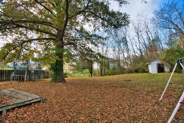 view of yard with a trampoline and a shed