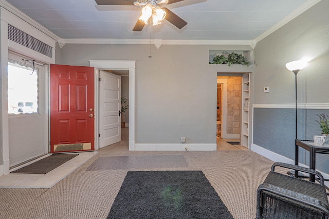 carpeted foyer featuring ceiling fan and crown molding