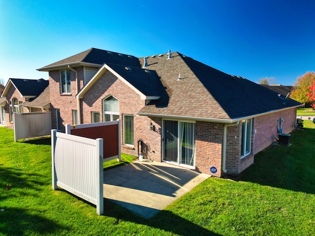 rear view of house featuring a patio area and a yard