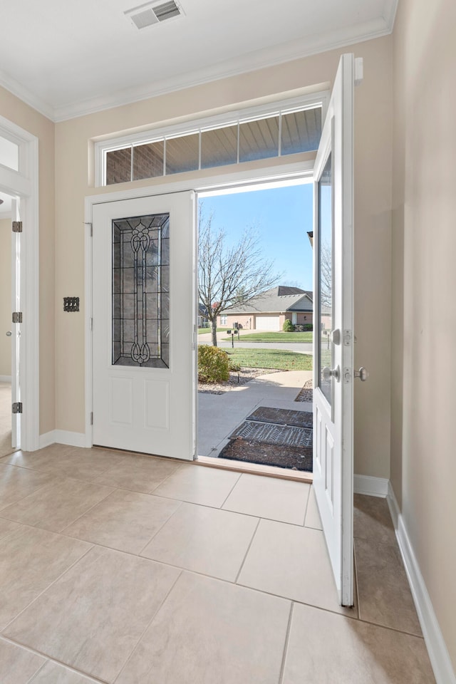 tiled foyer entrance featuring crown molding