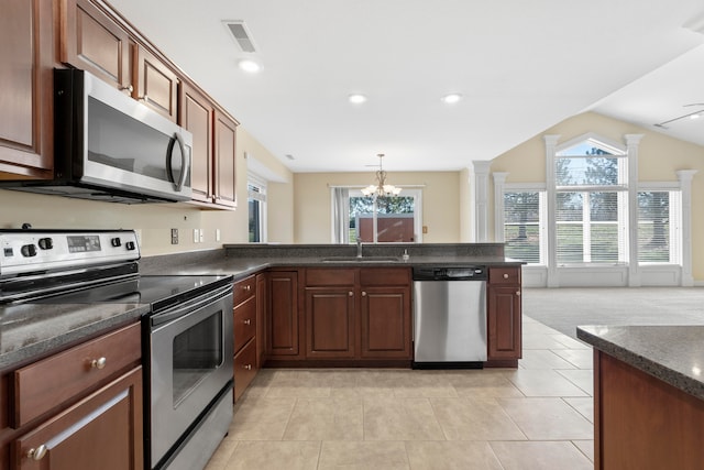 kitchen featuring sink, light tile patterned floors, stainless steel appliances, and vaulted ceiling