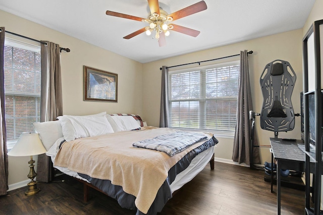 bedroom with multiple windows, dark hardwood / wood-style floors, and ceiling fan