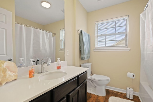 full bathroom with hardwood / wood-style flooring, vanity, toilet, and shower / bath combo with shower curtain