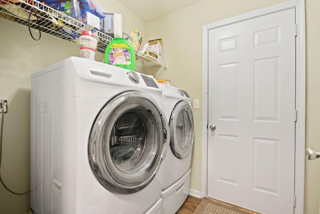 clothes washing area featuring washer and clothes dryer and hardwood / wood-style floors