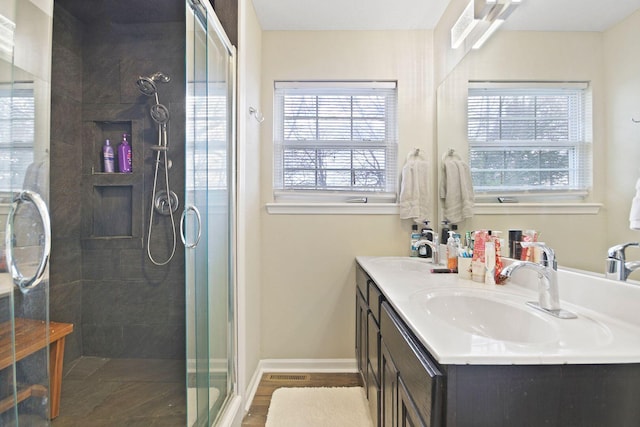 bathroom with plenty of natural light, an enclosed shower, wood-type flooring, and vanity