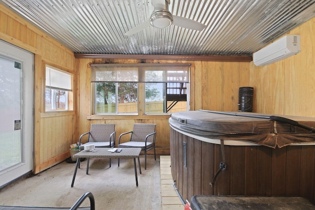 sunroom featuring plenty of natural light, a wall unit AC, and a hot tub