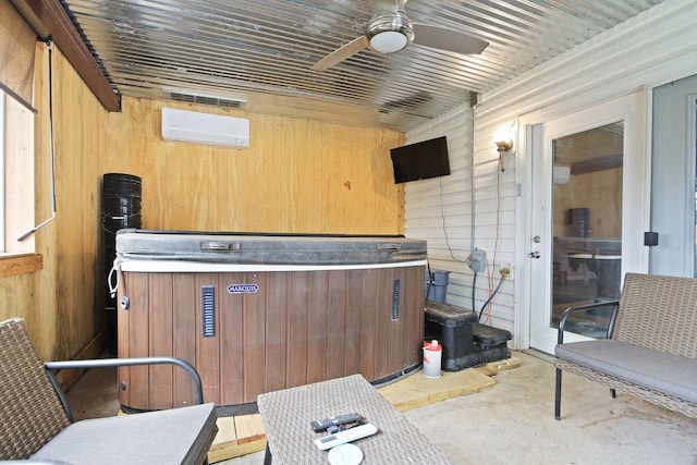 interior space featuring a hot tub, a wall mounted AC, and ceiling fan