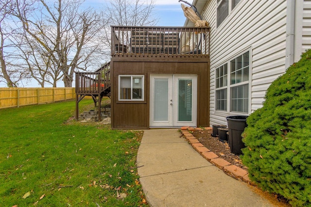 view of exterior entry featuring a lawn and french doors