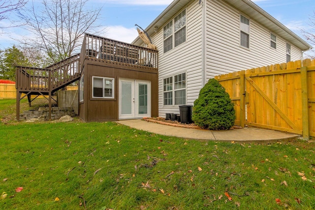 back of house with french doors, a deck, and a lawn