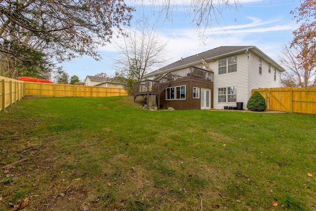 back of house featuring a lawn and a deck