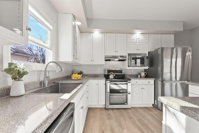 kitchen with light wood-type flooring, white cabinetry, sink, and appliances with stainless steel finishes