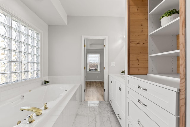 bathroom featuring vanity, a wealth of natural light, and tiled bath