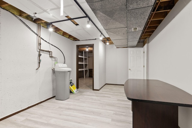 basement with light hardwood / wood-style flooring