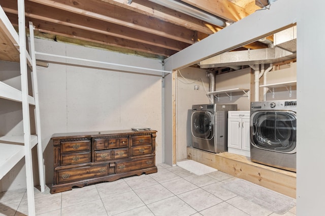 washroom with cabinets, light tile patterned floors, and washer and dryer