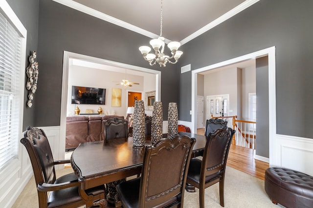 dining area featuring ornamental molding, ceiling fan with notable chandelier, and hardwood / wood-style flooring