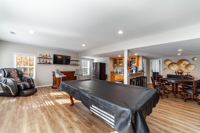 game room featuring bar area, light hardwood / wood-style floors, and pool table