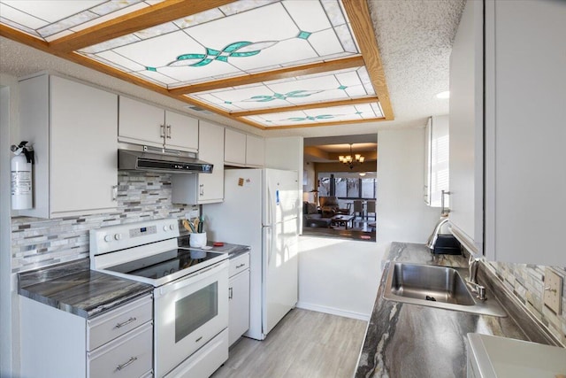 kitchen with an inviting chandelier, light hardwood / wood-style flooring, white appliances, decorative backsplash, and white cabinets