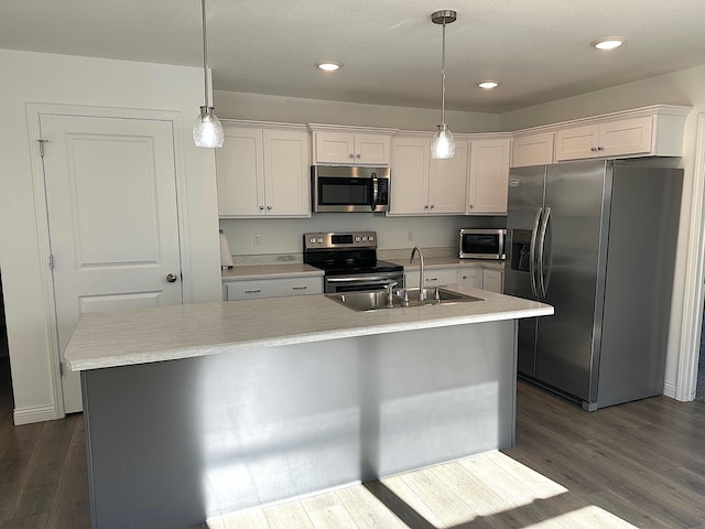 kitchen with a center island with sink, dark hardwood / wood-style floors, white cabinetry, and stainless steel appliances