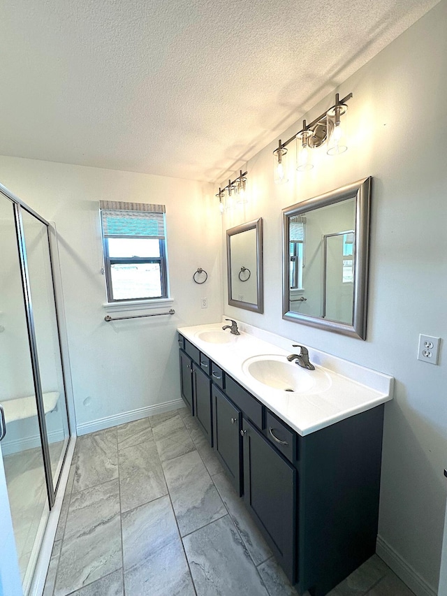 bathroom with vanity, a textured ceiling, and walk in shower