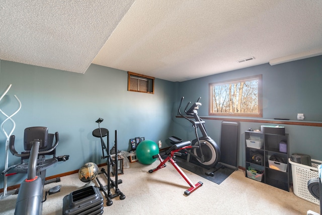 exercise area with carpet flooring and a textured ceiling