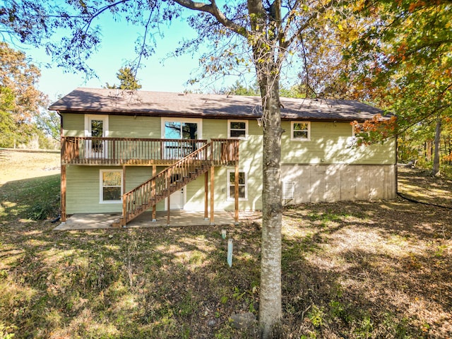 rear view of property with a yard, a patio area, and a wooden deck