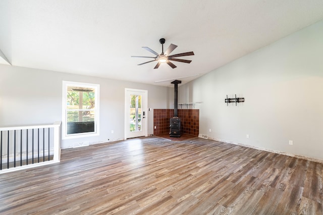 unfurnished living room with hardwood / wood-style flooring, ceiling fan, and a wood stove