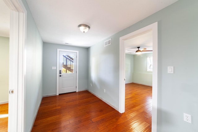 foyer entrance with ceiling fan and wood-type flooring