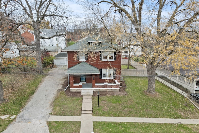 bungalow with an outbuilding and a front lawn