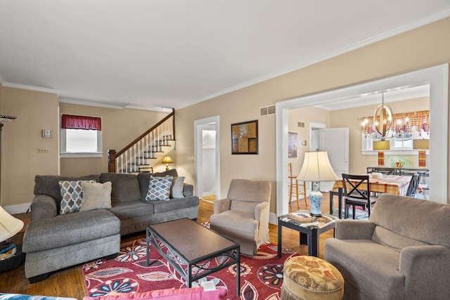 living room with wood-type flooring, an inviting chandelier, and ornamental molding