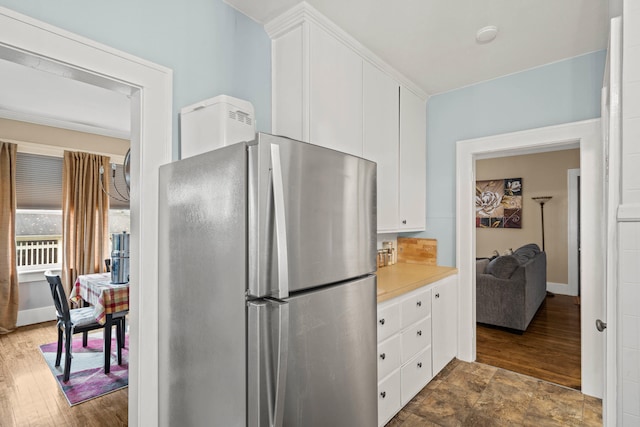 kitchen with stainless steel refrigerator, white cabinets, and dark hardwood / wood-style floors