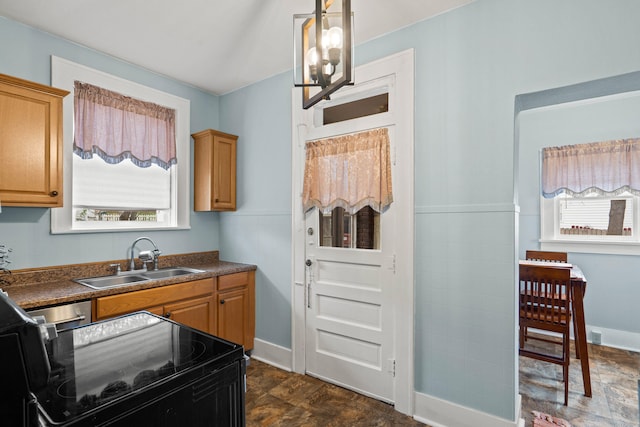 kitchen with sink, black range, decorative light fixtures, and plenty of natural light