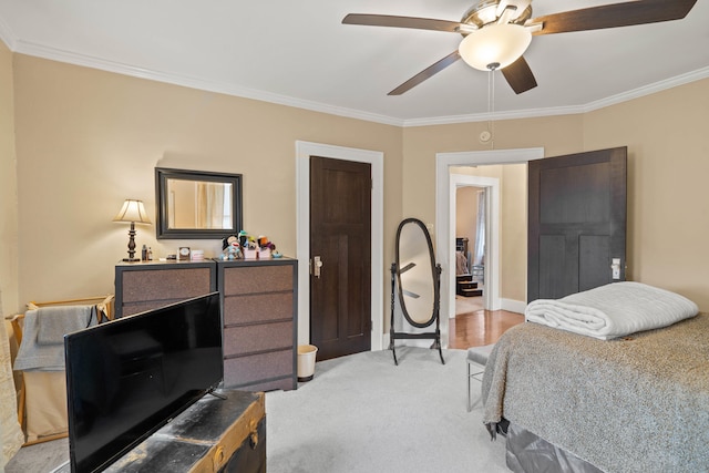 carpeted bedroom featuring ceiling fan and ornamental molding