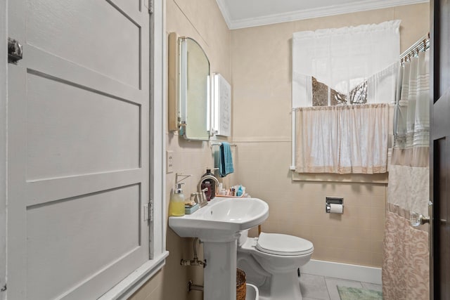 bathroom with tile patterned flooring, toilet, crown molding, and tile walls