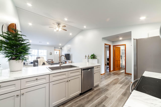 kitchen with light wood-type flooring, stainless steel appliances, ceiling fan, sink, and lofted ceiling