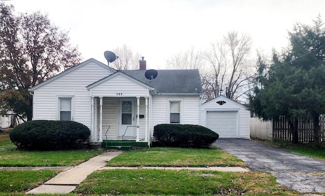 bungalow with a front yard, an outdoor structure, and a garage