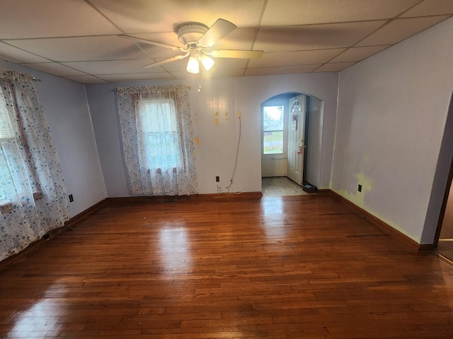 unfurnished room with a paneled ceiling, ceiling fan, and dark wood-type flooring