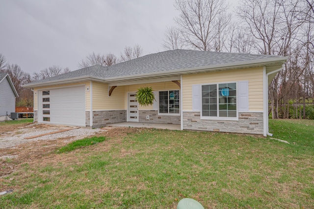 view of front of home featuring a front yard, a porch, a garage, and central AC unit