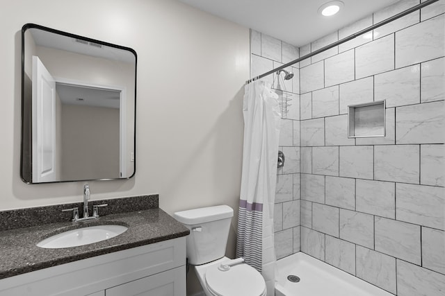 bathroom with curtained shower, vanity, and toilet