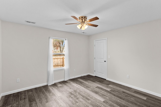 empty room with ceiling fan and dark wood-type flooring