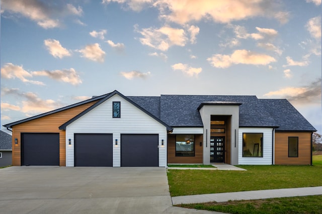 view of front of home with a yard and a garage