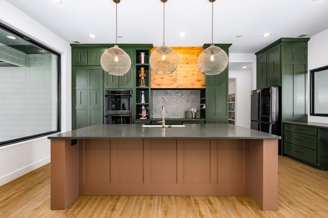 kitchen with hanging light fixtures, sink, and a kitchen island with sink