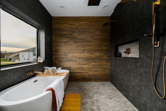 bathroom with tile patterned flooring, plenty of natural light, shower with separate bathtub, and wooden walls