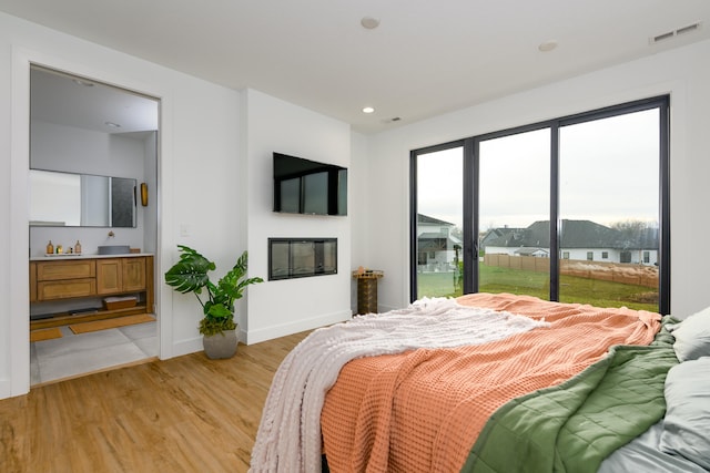 bedroom featuring access to exterior and light wood-type flooring