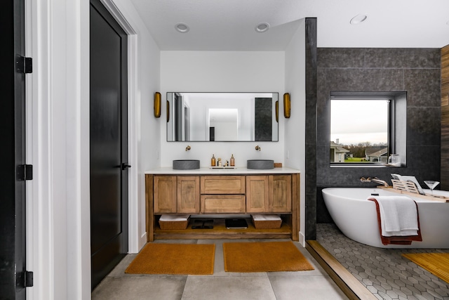 bathroom featuring vanity, tile walls, and a tub