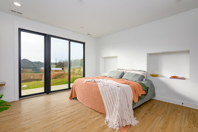 bedroom with access to outside and light hardwood / wood-style floors