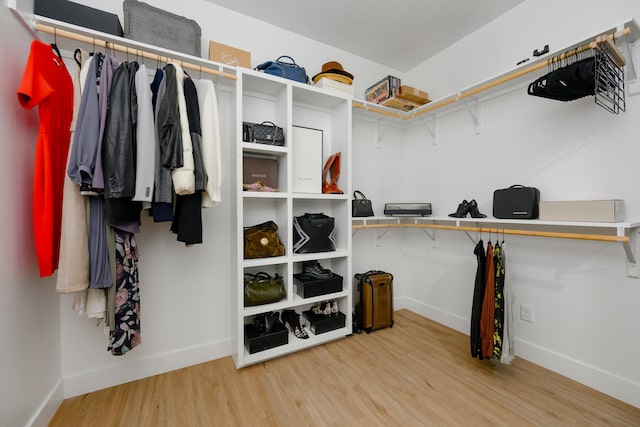 walk in closet with light hardwood / wood-style floors